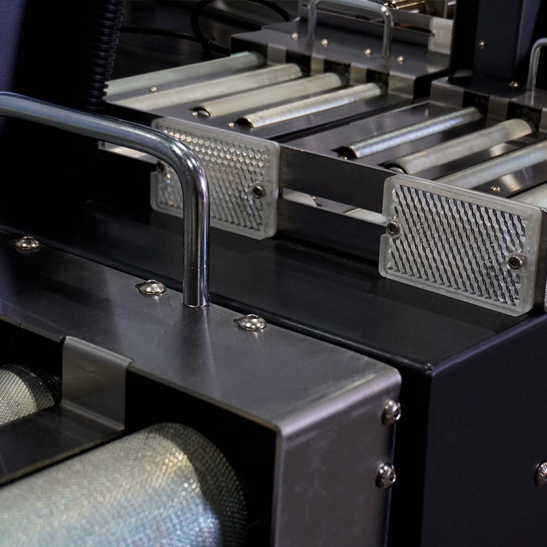Detalhe dos sensores fotoelétricos reflexivos que detectam a caixa sobre os roletes